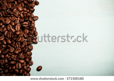 Coffee beans on blue wooden table. Toned.