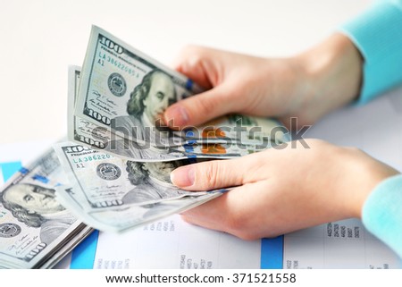 Woman counting money at the table