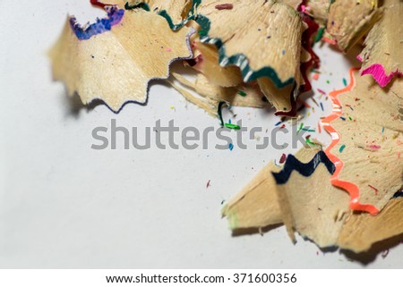 Closeup image of brightly coloured school pencil sharpening shavings on a white background. Copyspace for educational reference or education themed designs.