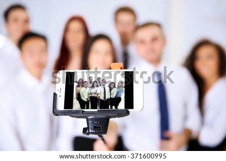 Young people making group photo with smart phone in office
