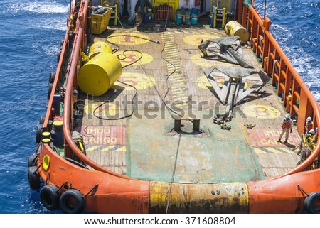 Anchor handling tug deploying anchors of construction barge at oilfield Terengganu, Malaysia

