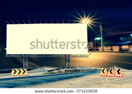billboard and bridge with light on road in night time