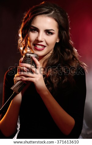 Portrait of beautiful singing woman on red background, close up