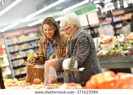 Elderly woman with young woman at the grocery store Royalty-Free Stock Photo #371623984