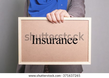 Businesswoman holding a softboard written Insurance