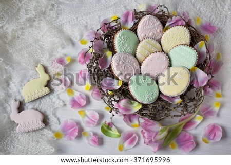Easter Nest with cookies gingerbread in the form of eggs and bunny rabbits, flower petals tulips