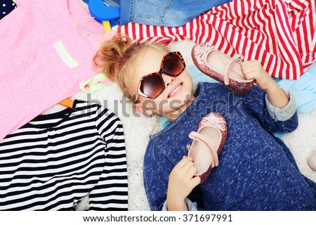 Little girl and new clothes, top view Royalty-Free Stock Photo #371697991