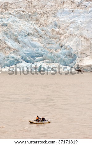 rafters dwarfed by massive glacier