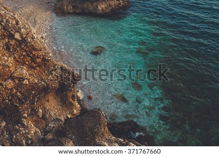 Calm blue sea and rocks. Vintage effect image. Rocky shore. Toned photo.