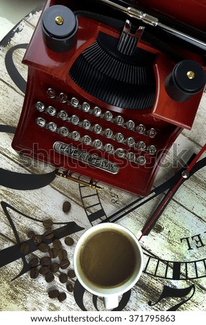 Cup of coffee and typewriter with coffee beans on wooden clock