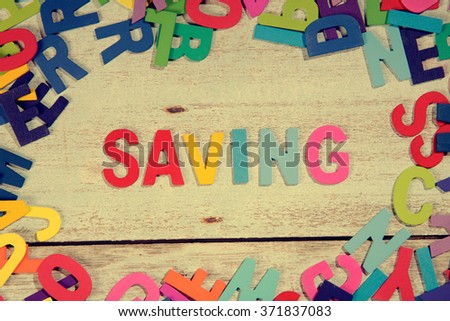 savings word block concept photo on plank wood

