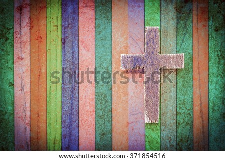 Wooden cross on  multi painted color background, copy space