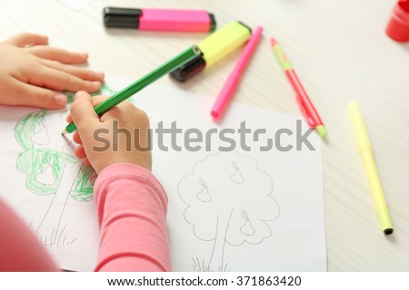 Child drawing tree with pencils on paper, closeup