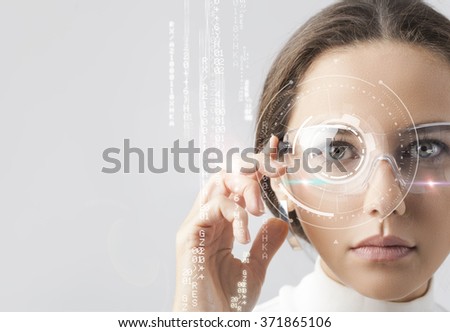 Young woman looking at virtual graphics in futuristic background Royalty-Free Stock Photo #371865106