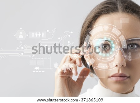 Young woman looking at virtual graphics in futuristic background Royalty-Free Stock Photo #371865109