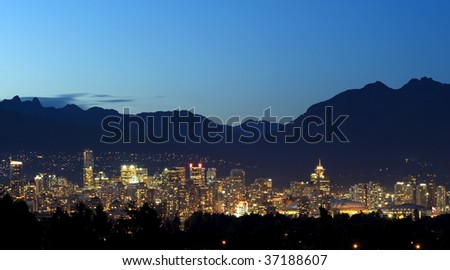 Vancouver Canada at night set in between the trees and the North Shore mountains.