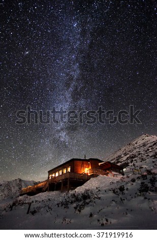 Milky way over winter mountain landscape with cottage, Slovakia Tatras