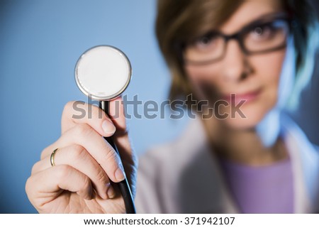 woman doctor holding a stethoscope in her outstretched hand