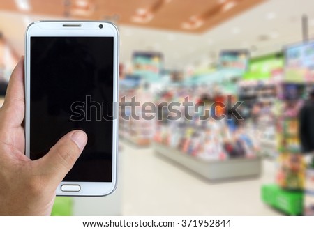 Man use mobile phone, blur image of book store as background.