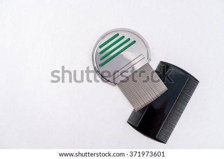 Two louse combs for lice treatment made of shiny metal and black plastic. 