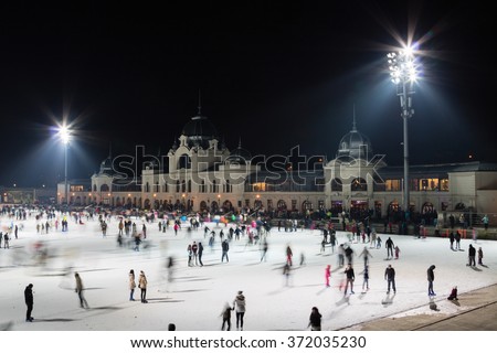 Ice skaters on public rink of Budapest City Park Royalty-Free Stock Photo #372035230