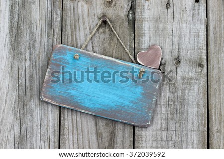 Blank teal blue wood sign hanging on antique rustic wooden background; Valentines Day, Mothers Day, family and love concept background with painted copy space