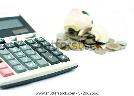 Financial calculator and blur stack coins with broken piggy bank on white background, concept photo