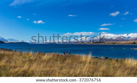 Panoramic view which Landscape of cloudy with blue sky all around the Tekapo lake and a snow mountain background,New zealand