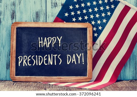 the text happy presidents day written in a chalkboard and a flag of the United States, on a rustic wooden background Royalty-Free Stock Photo #372096241