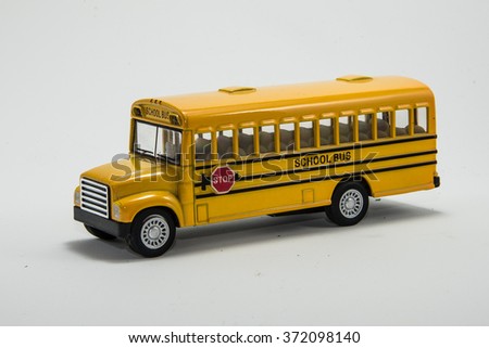 Yellow school bus toy model isolated with path.