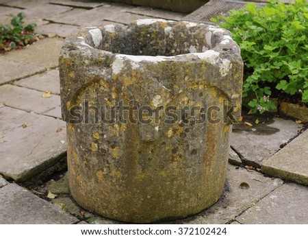 An Antique Stone Pot in a Country Cottage Garden in the Rural Village of Tintinhull in Somerset, England, UK