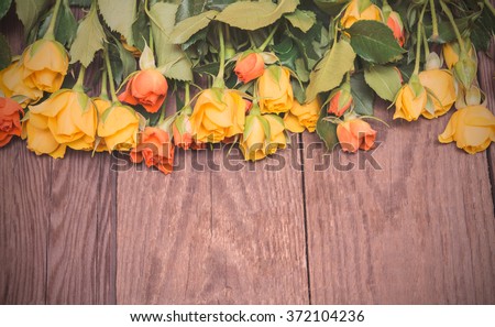 Yellow and orange roses on a wooden background. Women' s day, Valentines Day, Mothers day. Copy space, selective focus, toned