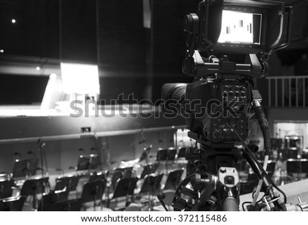 Professional digital video camera. accessories for 4k video cameras. tv camera in a concert hall. 
black and white photo