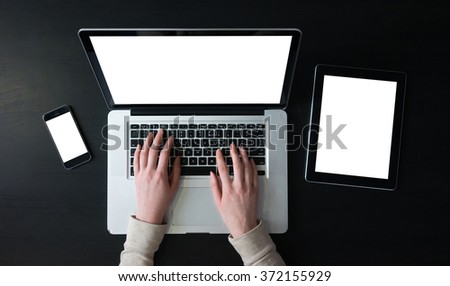 businesswoman work on notebook on modern coffee table with smart phone and a tablet next to her, student use technology for connection with isolated screens
