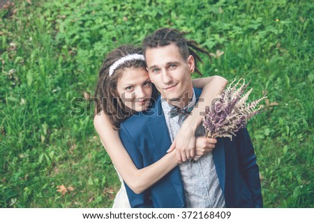 The couple with dreadlocks posing in her wedding day