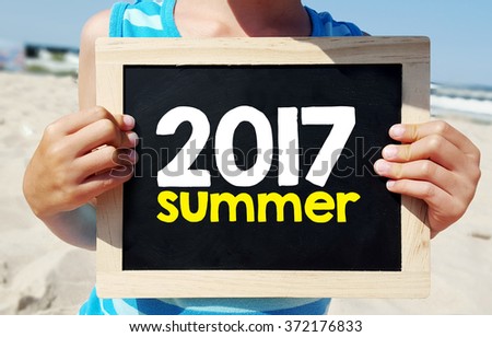 Hands holding blackboard with summer 2017