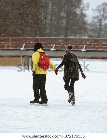 Young couple going Ice skating on Trakai ice covered lake. Skating involves any activity which consists of traveling on ice using skates
