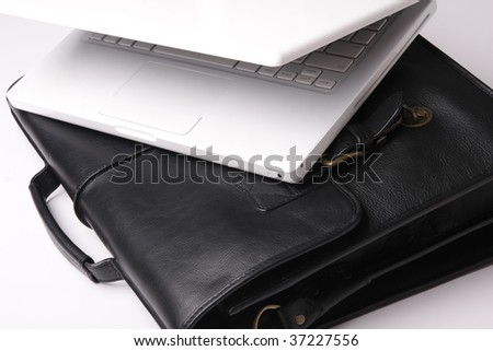 Laptop and brief-case on a white background. Nobody, business concept image.