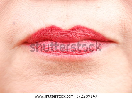 Macro closeup  mouth of woman with red lipstick makeup.