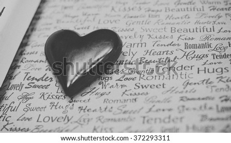 Chocolate heart on newspaper texture. Romantic background