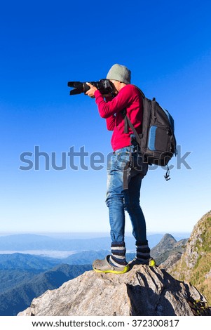 Thai photographer or traveller using a professional DSLR camera in the nature for background