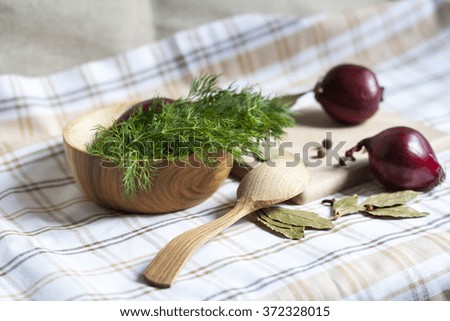 Fresh green dill in wooden plate, spices and red onions
*small depth of field to focus on individual details