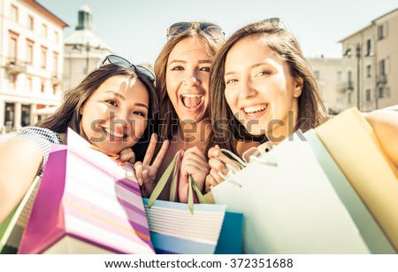Three happy girls having fun and making shopping