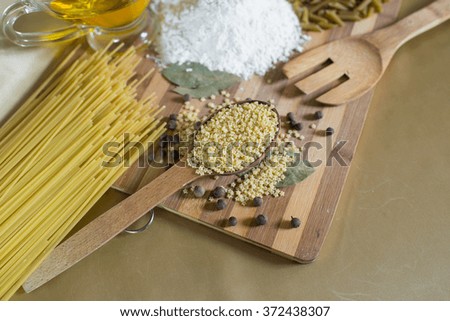 pasta as asterisks on a wooden spoon on the board with flour