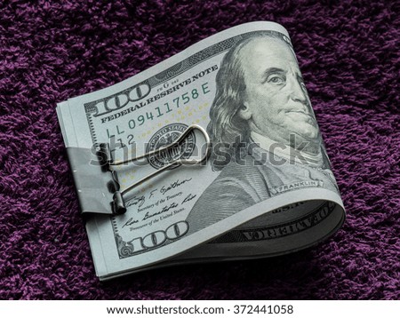 Roll of dollars on a purple background