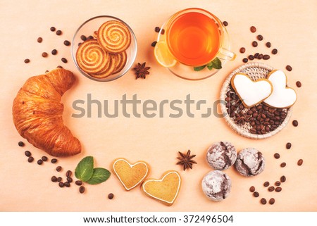 Frame made with cookies, croissant, coffee beans and cup of tea. Carbohydrates are bad for diet. 
