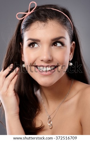 Portrait of happy young excited woman looking up, hand in hair.