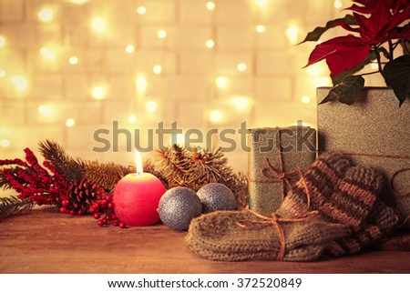 Pair of knitted socks with wrapped gifts for Christmas on brick wall background