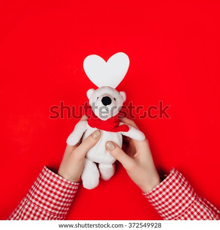 woman holding white bear on red