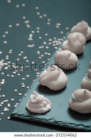 Set of small profiteroles on a black slate plate. Selective focus. Toned.